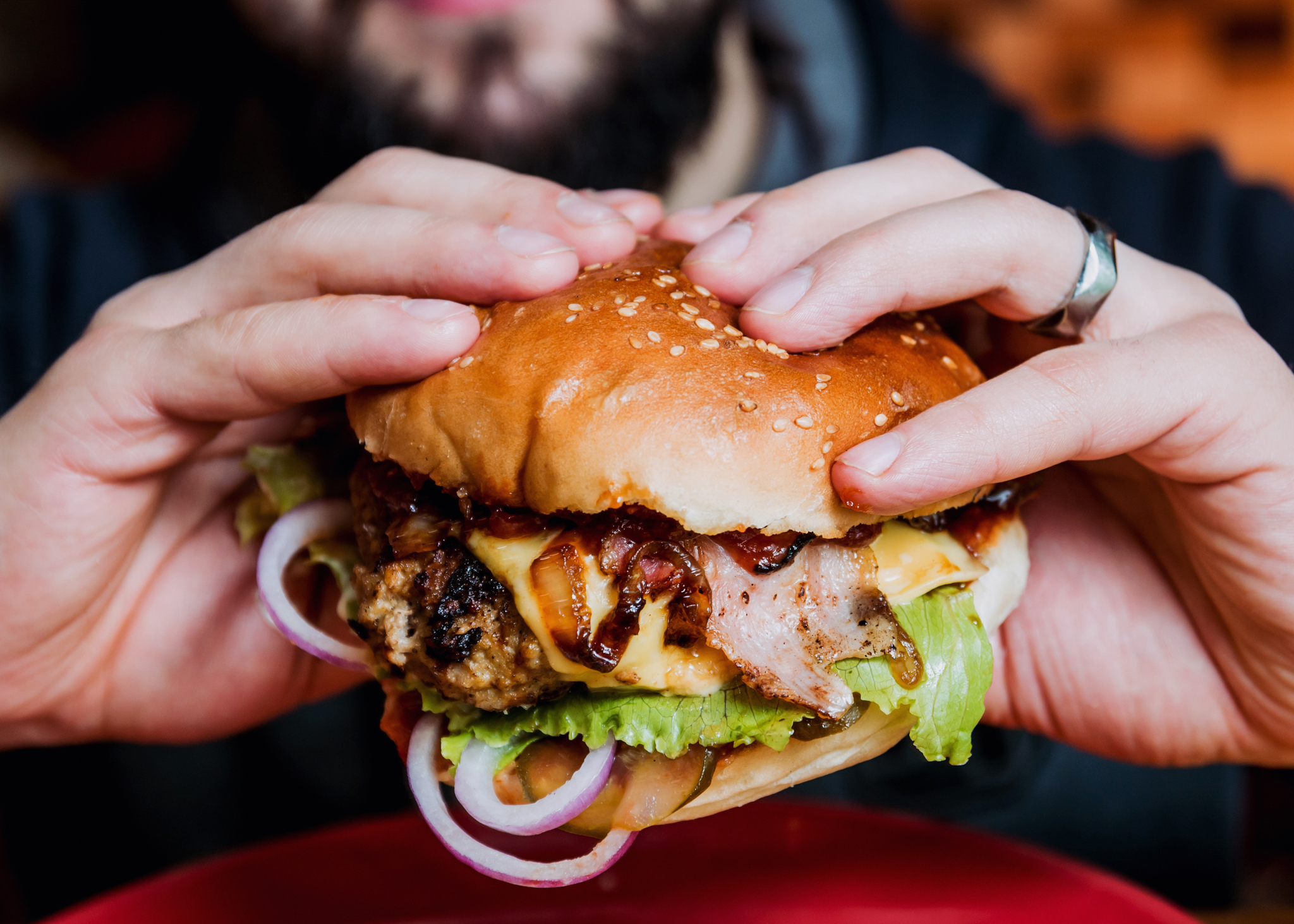 Young man eating a cheeseburger.